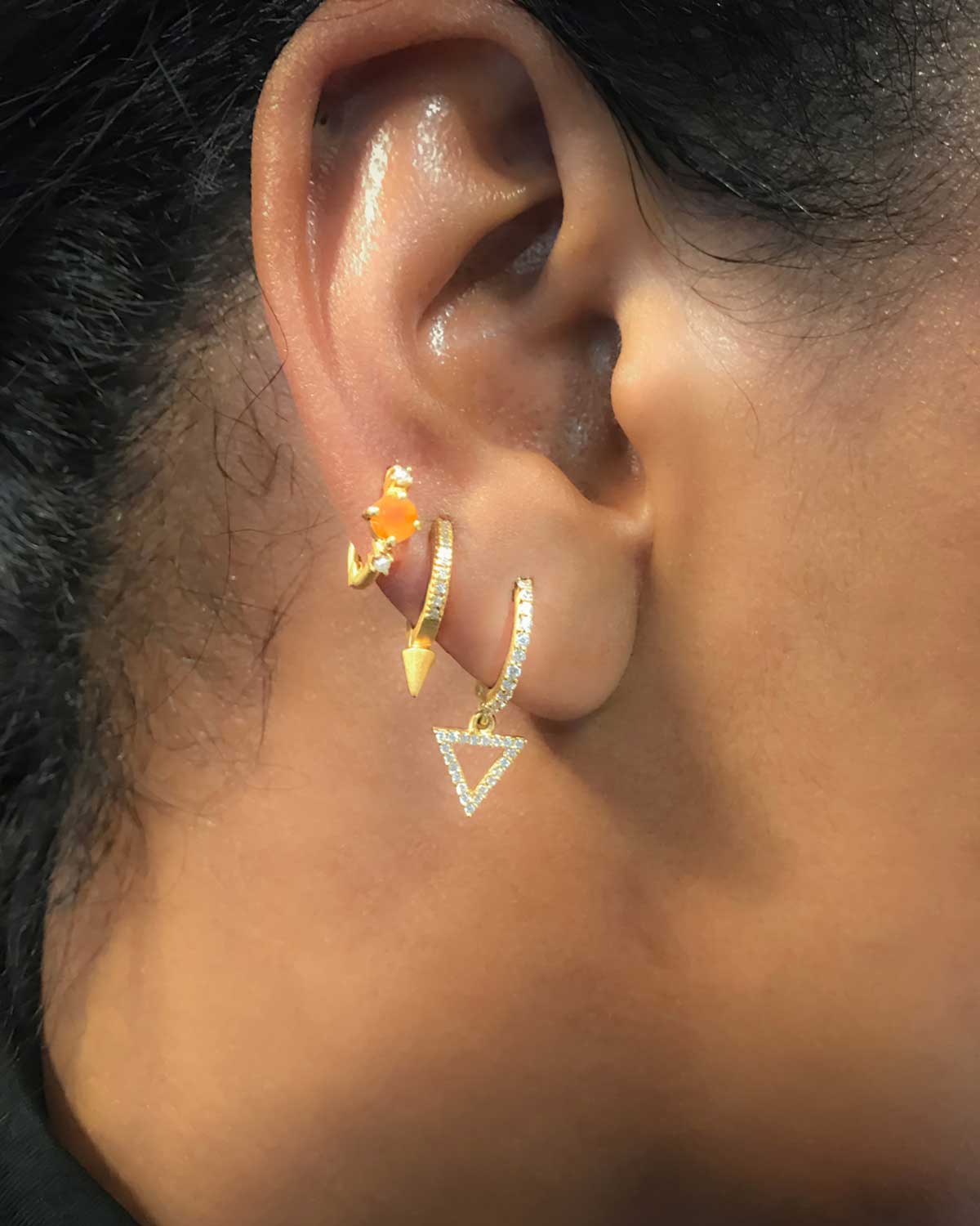 Close-up of gold mini hoops with triangle charm and AAA crystals