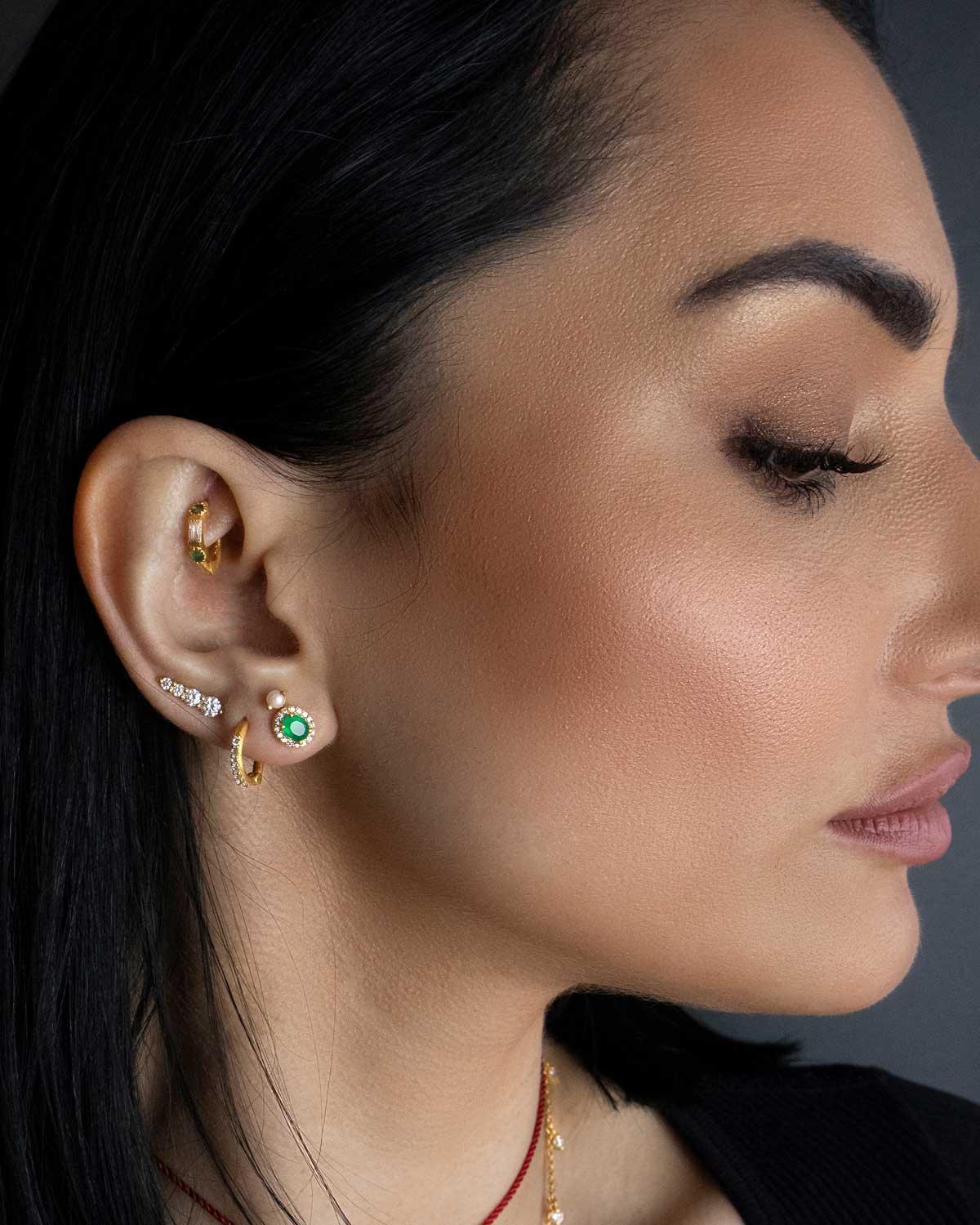 Close-up of green onyx stud earrings with cabochon cut and crystal border