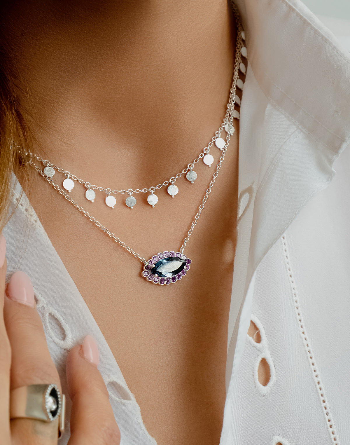 Gold eye necklace styled in a layered look with other necklaces