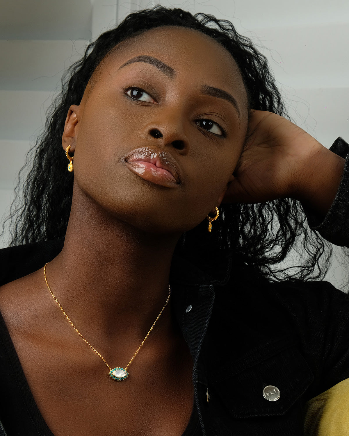 Gold eye necklace with polished finish and gemstone detailing