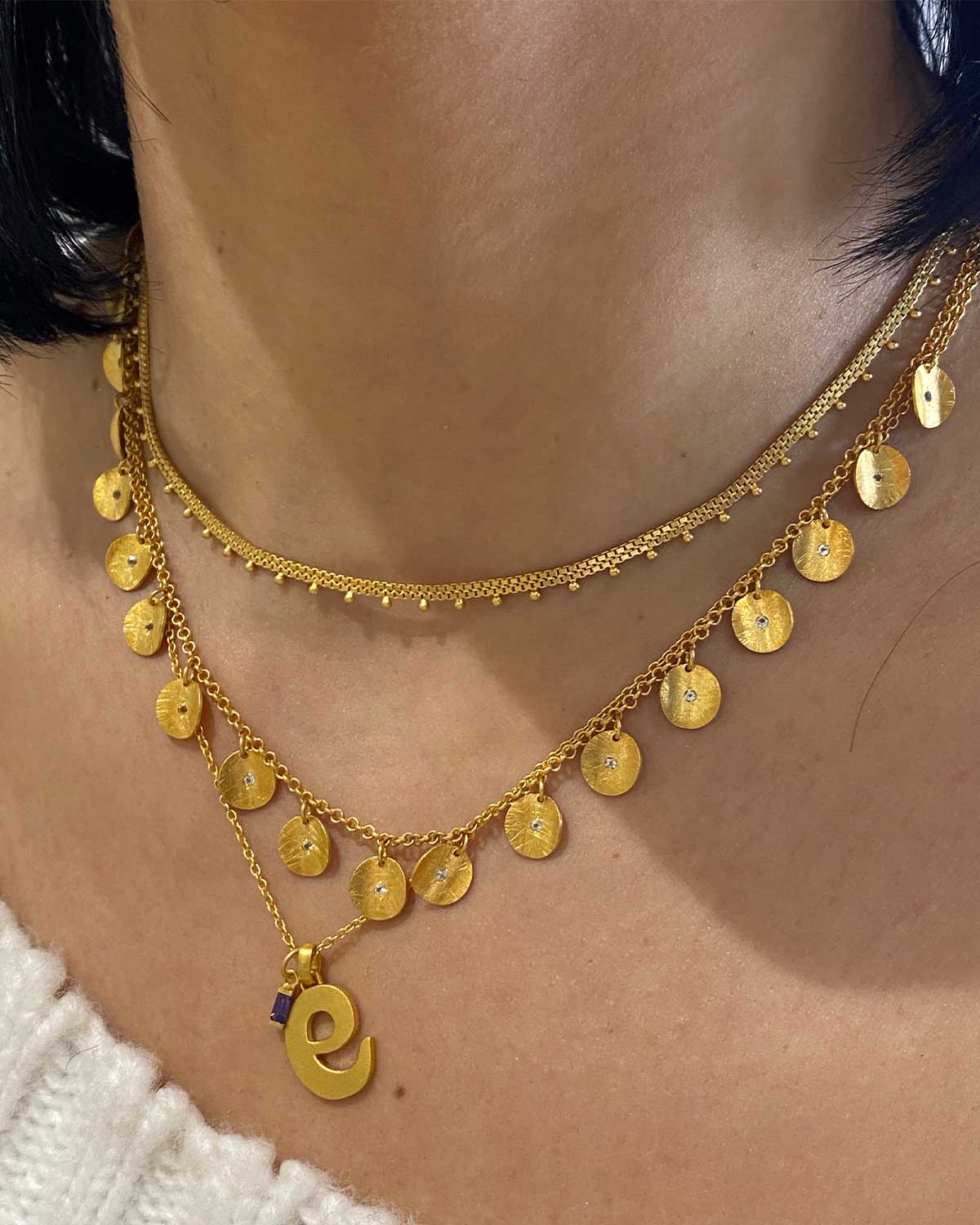 Close-up of gold necklace with amethyst and diamond-cut crystals