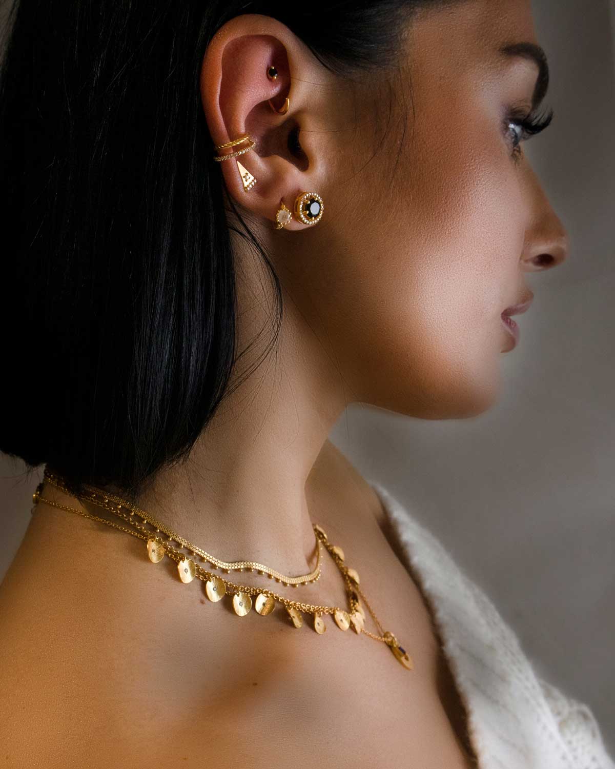 Model wearing gold necklace with amethyst and crystal details