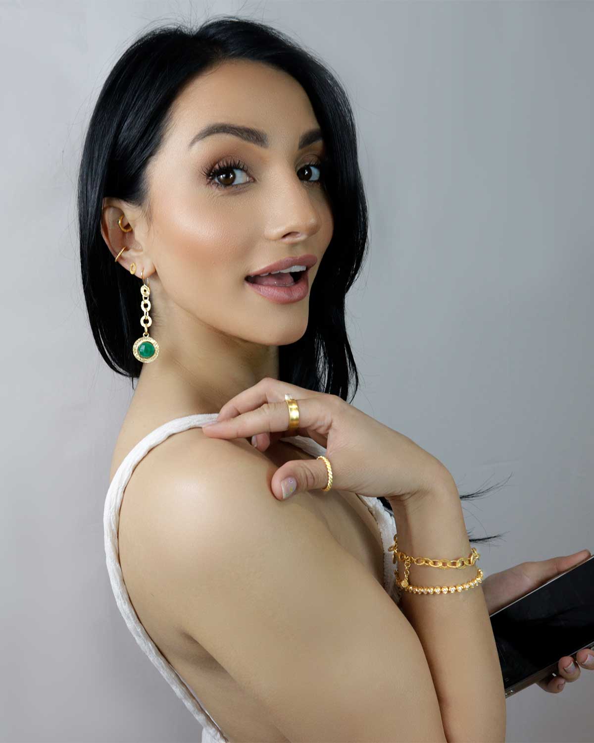 Close-up of emerald green gemstone drop earrings with gold detailing