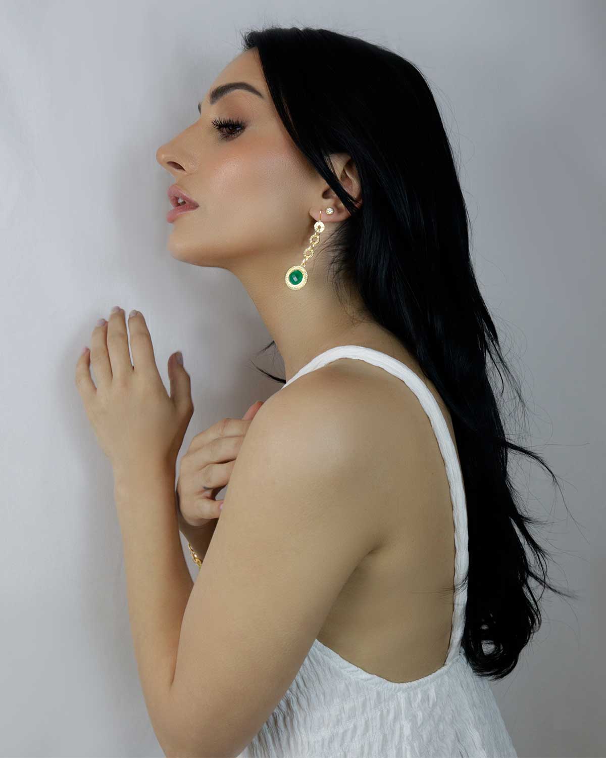 Gold drop earrings with emerald green gemstones and light matte finish