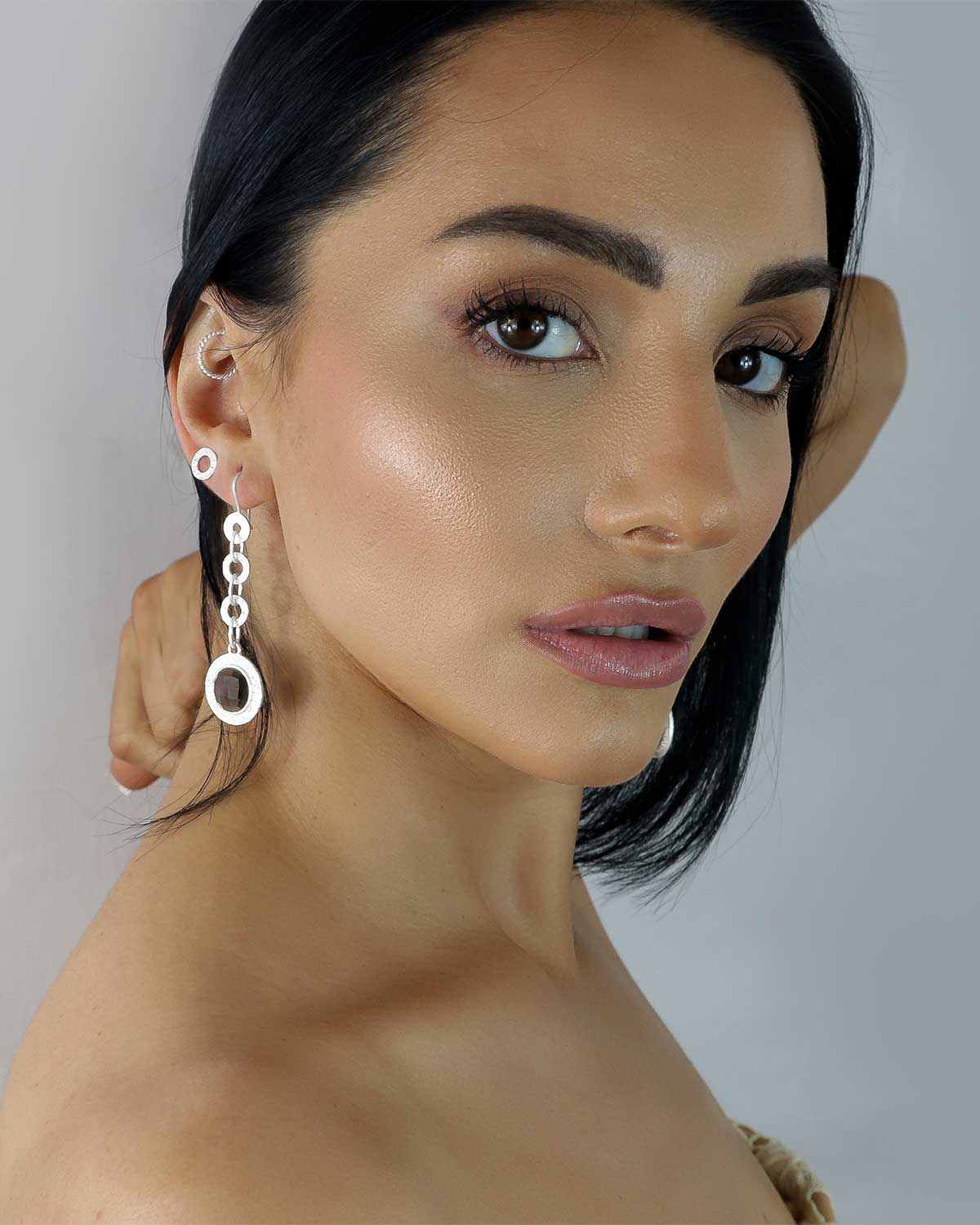 Model wearing silver drop earrings with smoky quartz gemstones