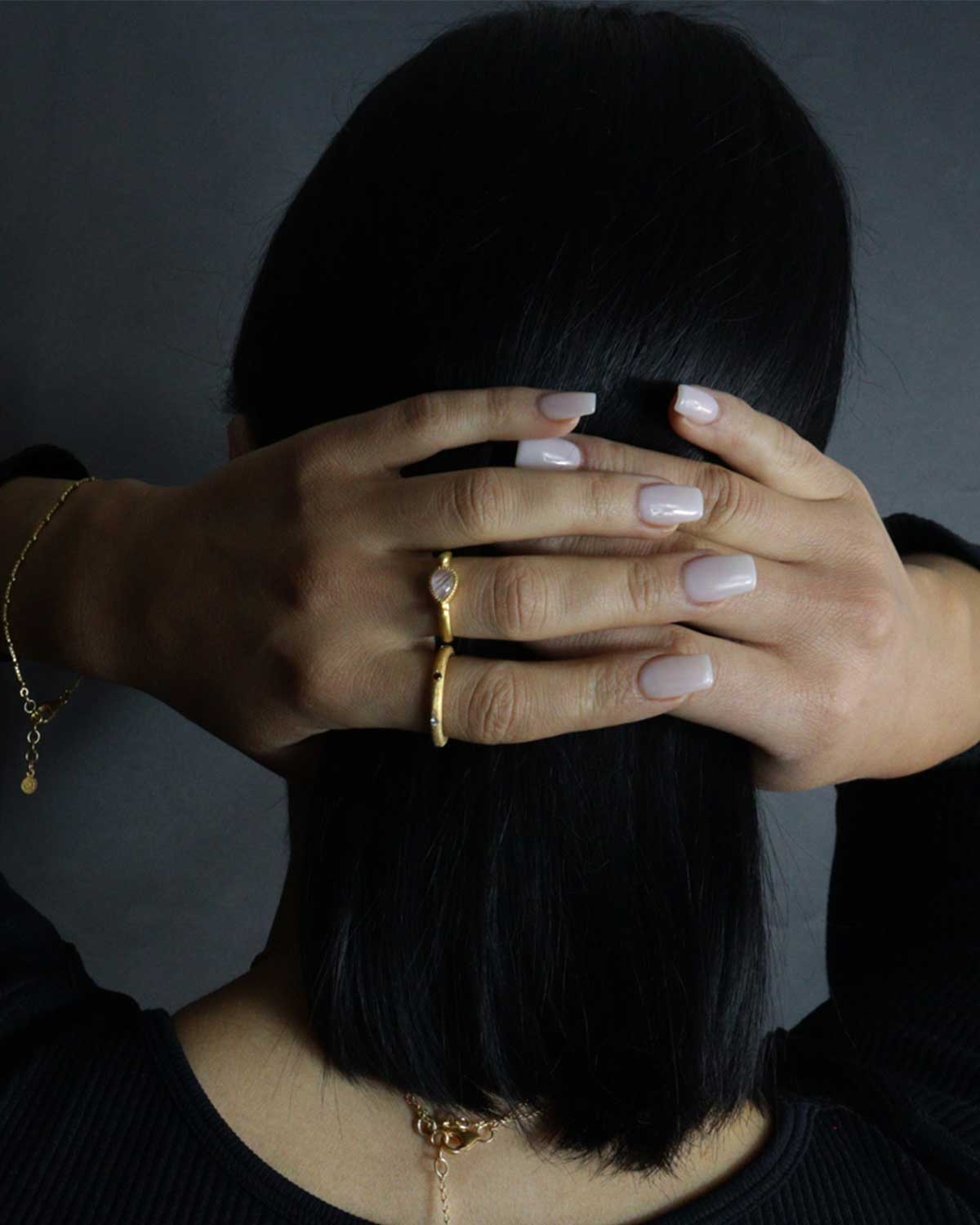 Model wearing rainbow moonstone gold ring in elegant style