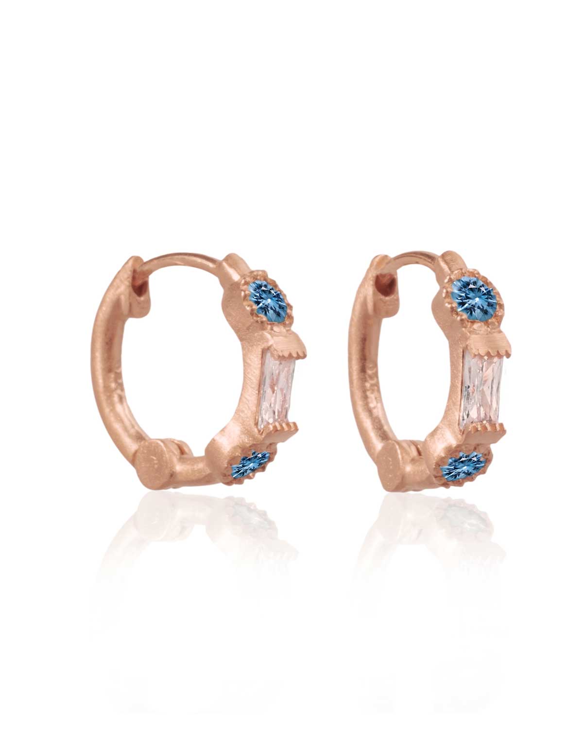 Gold mini hoops with blue topaz styled in a stacked look