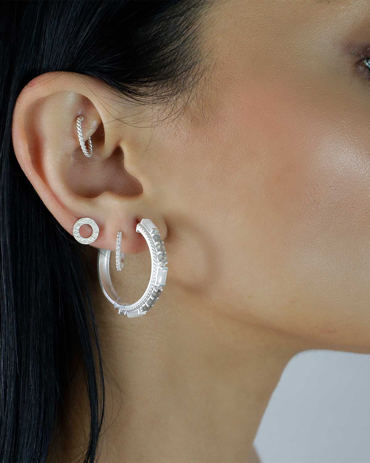 Side angle of silver hoop earrings with rainbow moonstone and labradorite