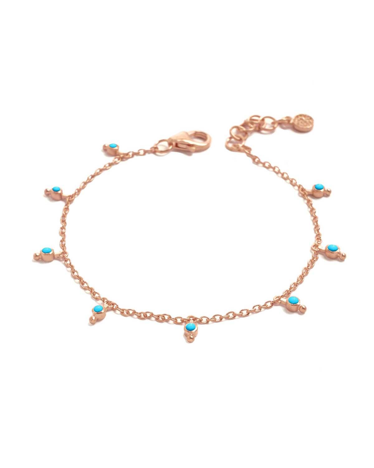 Close-up of bracelet with turquoise gemstones and handcrafted ball charm