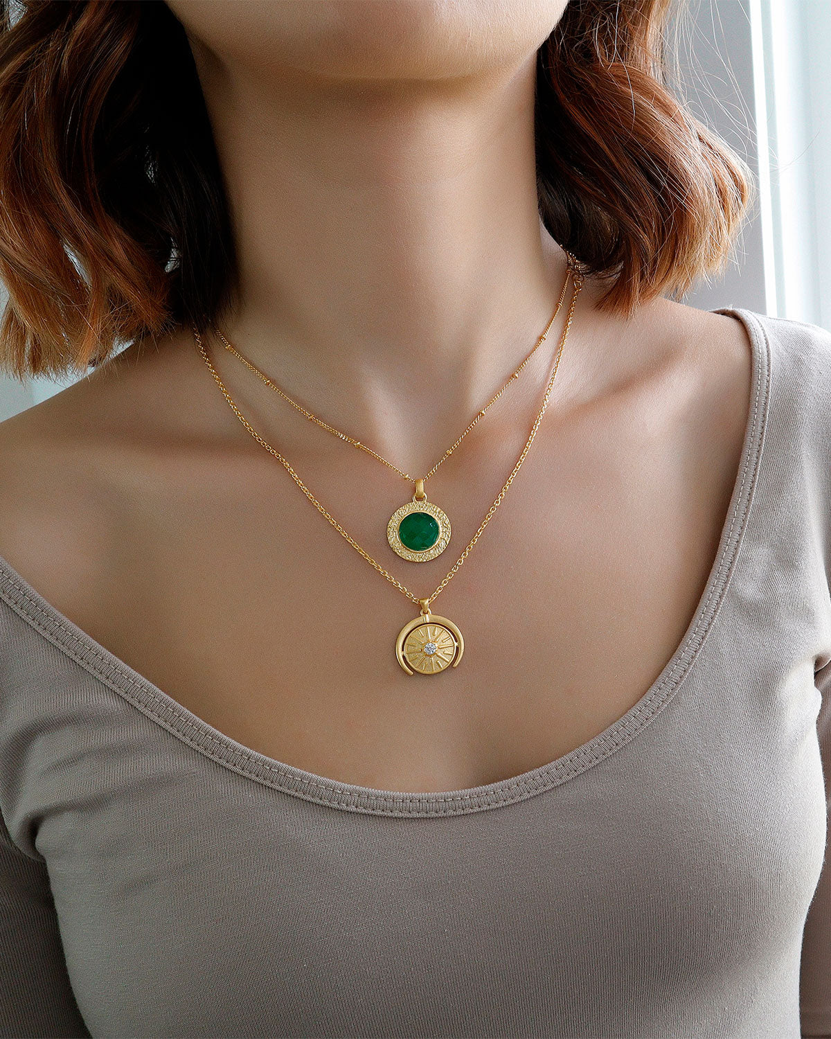 Gold necklace featuring a bold circular green onyx pendant