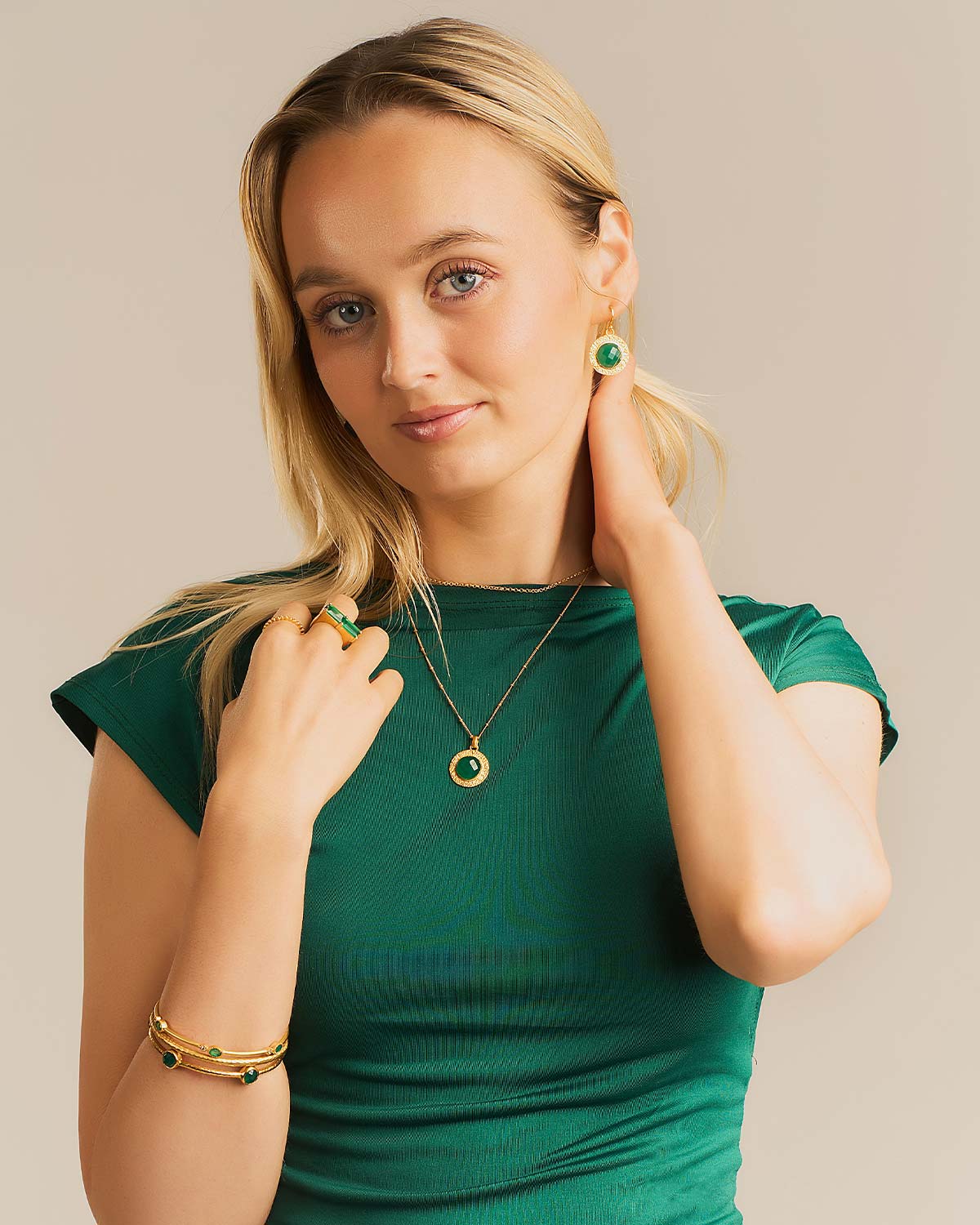 Model wearing sterling silver earrings with circular green onyx gemstones