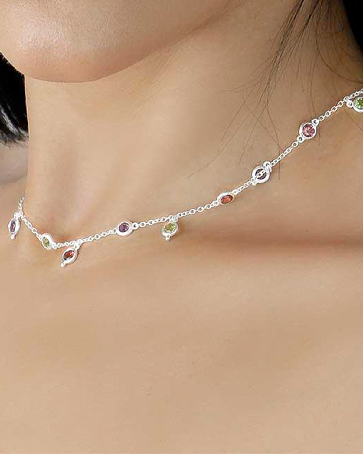 Model wearing silver necklace with mixed gemstones