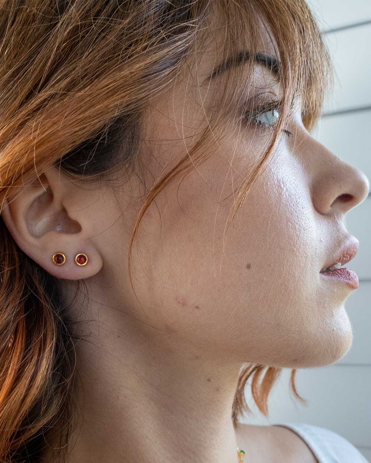 Model wearing everyday garnet stud earrings for a subtle look