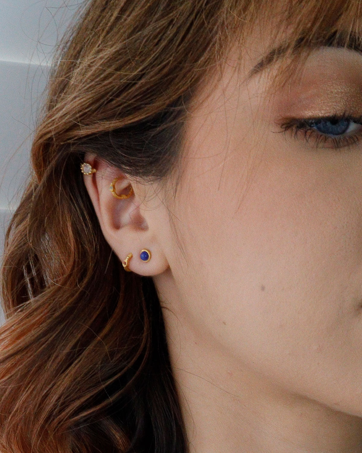 Close-up of lapis lazuli stud earrings with deep blue stone