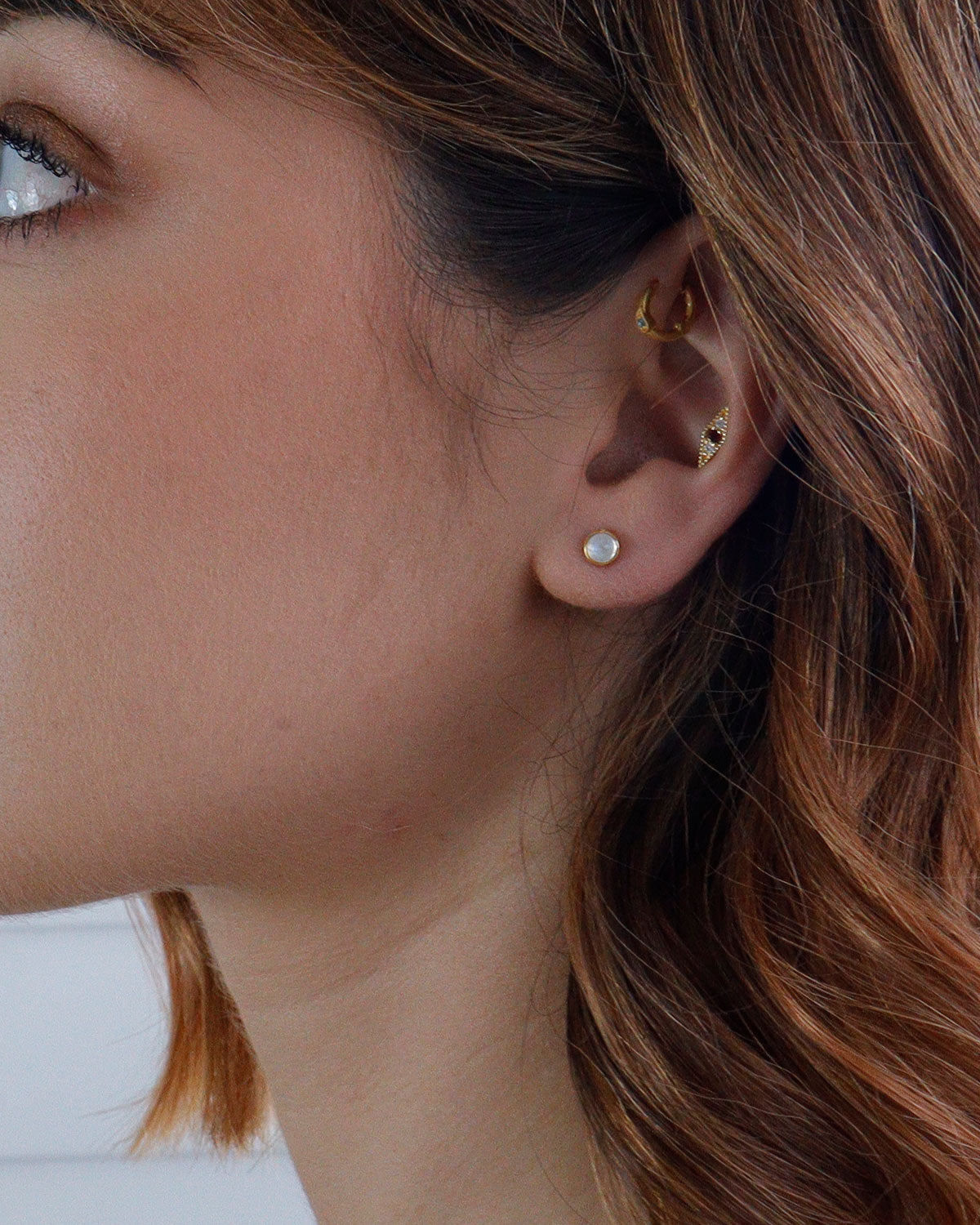 Close-up of moonstone stud earrings with soft rainbow glow