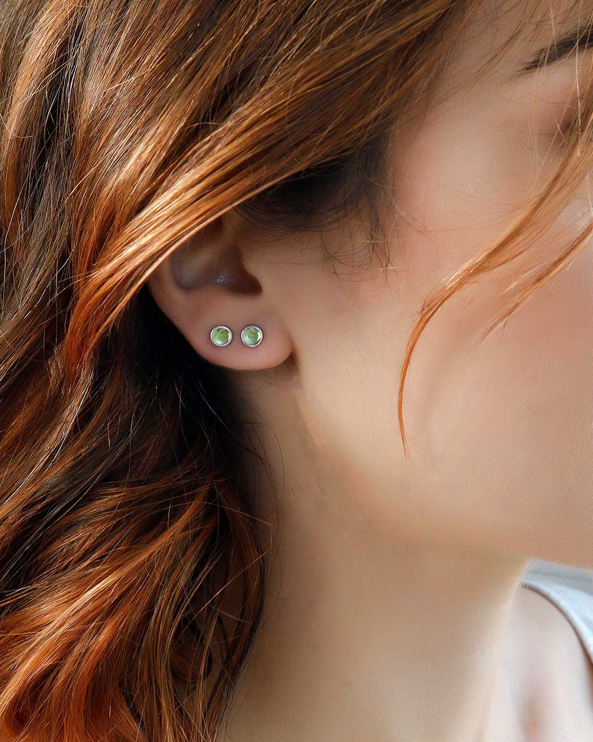 Close-up of peridot stud earrings with bright green gemstone