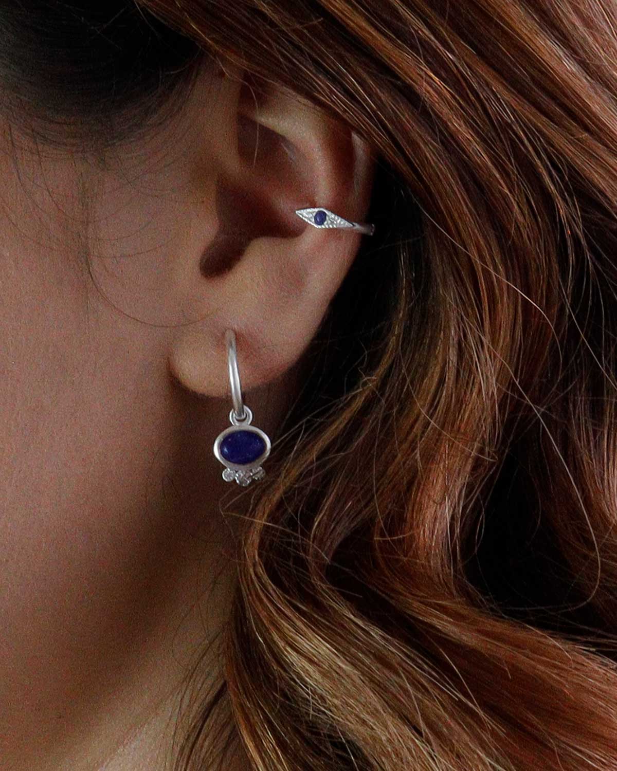 Close-up of lapis lazuli charm with tiny crystal details on silver mini hoops
