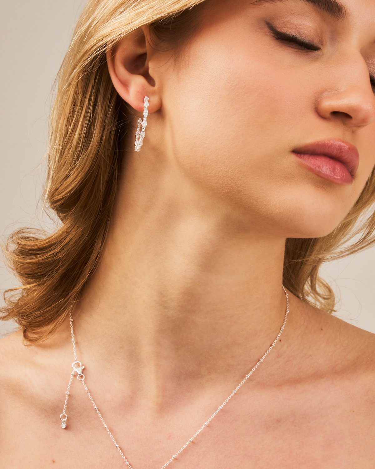 Silver hoop earrings with a polished finish and sparkling zirconia gemstones