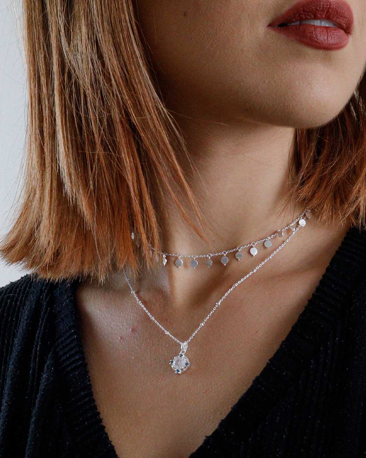 Close-up of silver necklace with moonstone and blue topaz gemstones