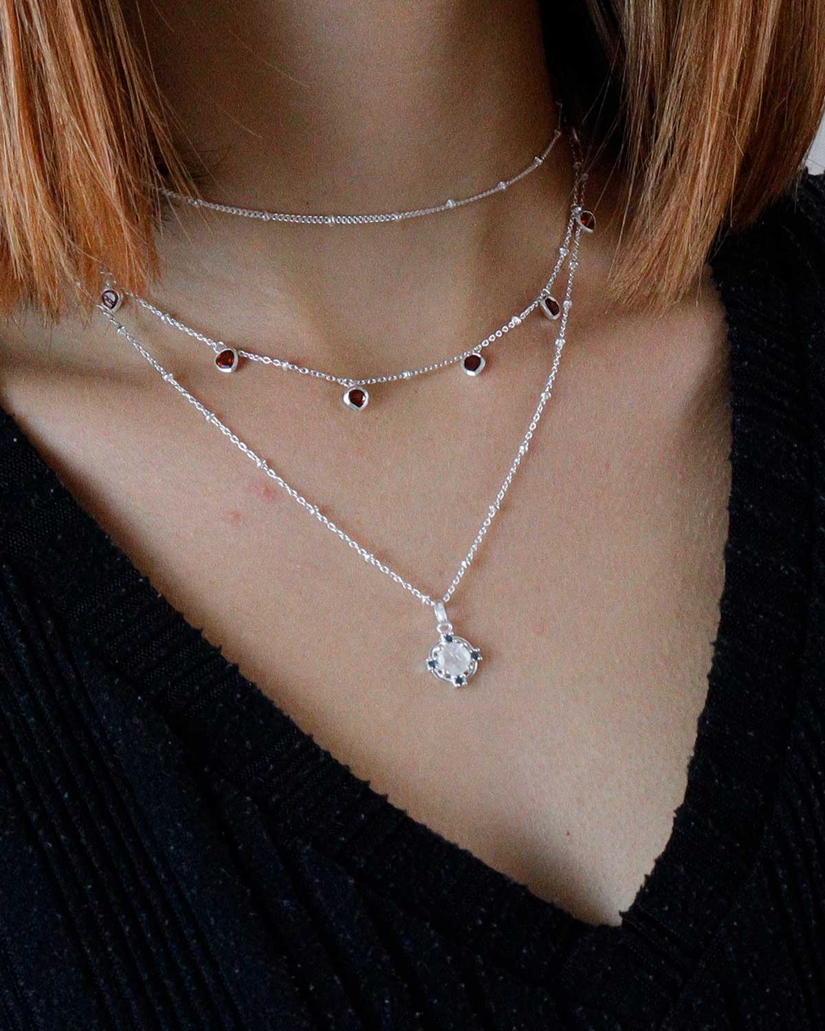 Model wearing silver necklace with moonstone and blue topaz