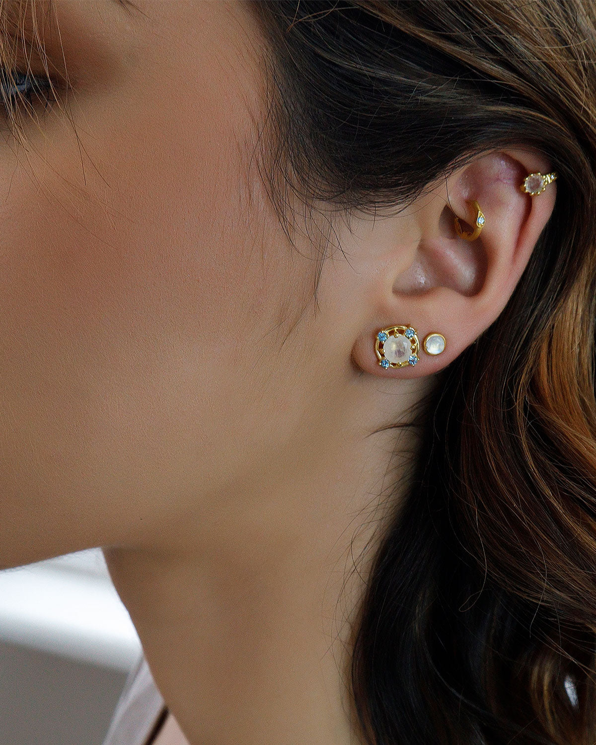 Gold stud earrings with moonstone and blue topaz in a polished finish