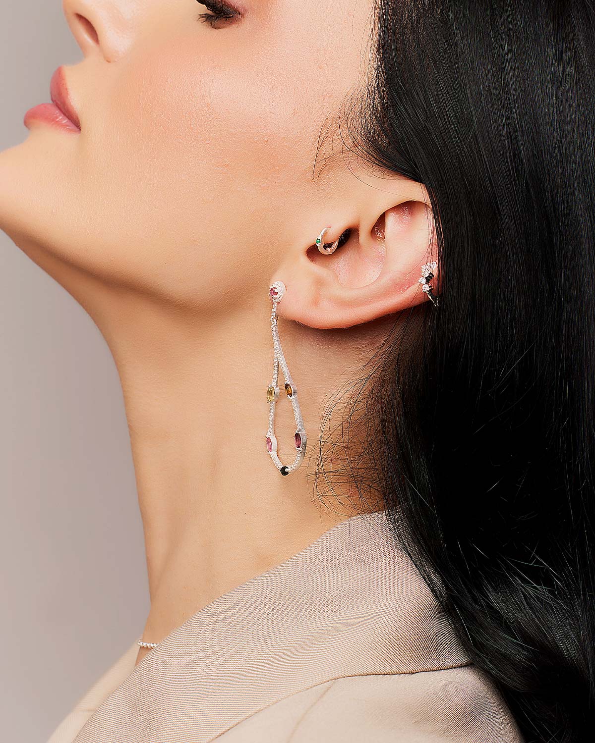 Model wearing silver drop earrings with faceted mixed tourmaline gemstones