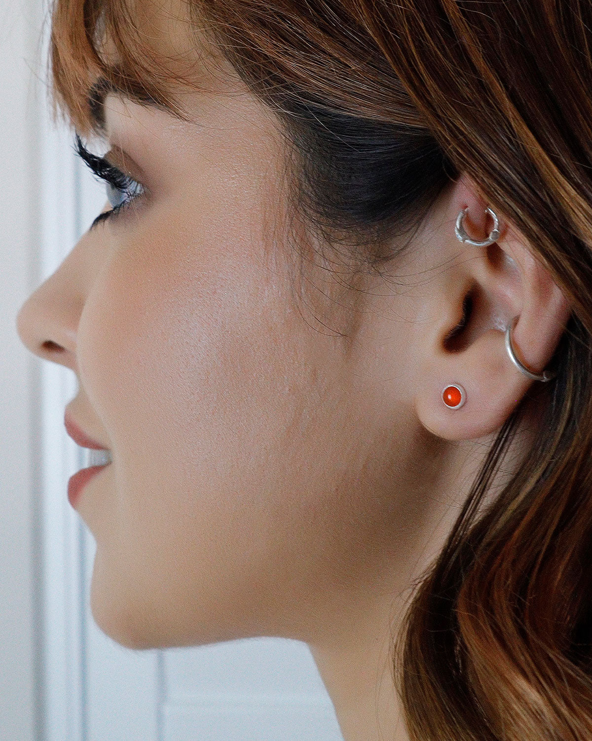 Close-up of carnelian gemstone stud earrings with a polished finish