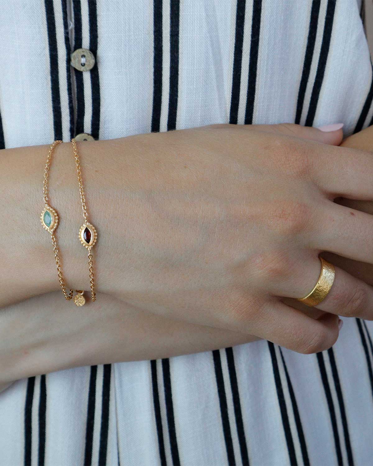 Front view of gold bracelet with eye design and natural gemstones