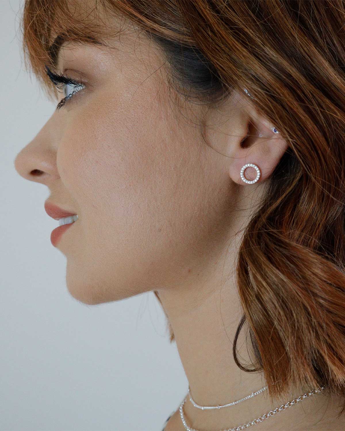 Close-up of circular silver stud earrings with AAA grade crystals