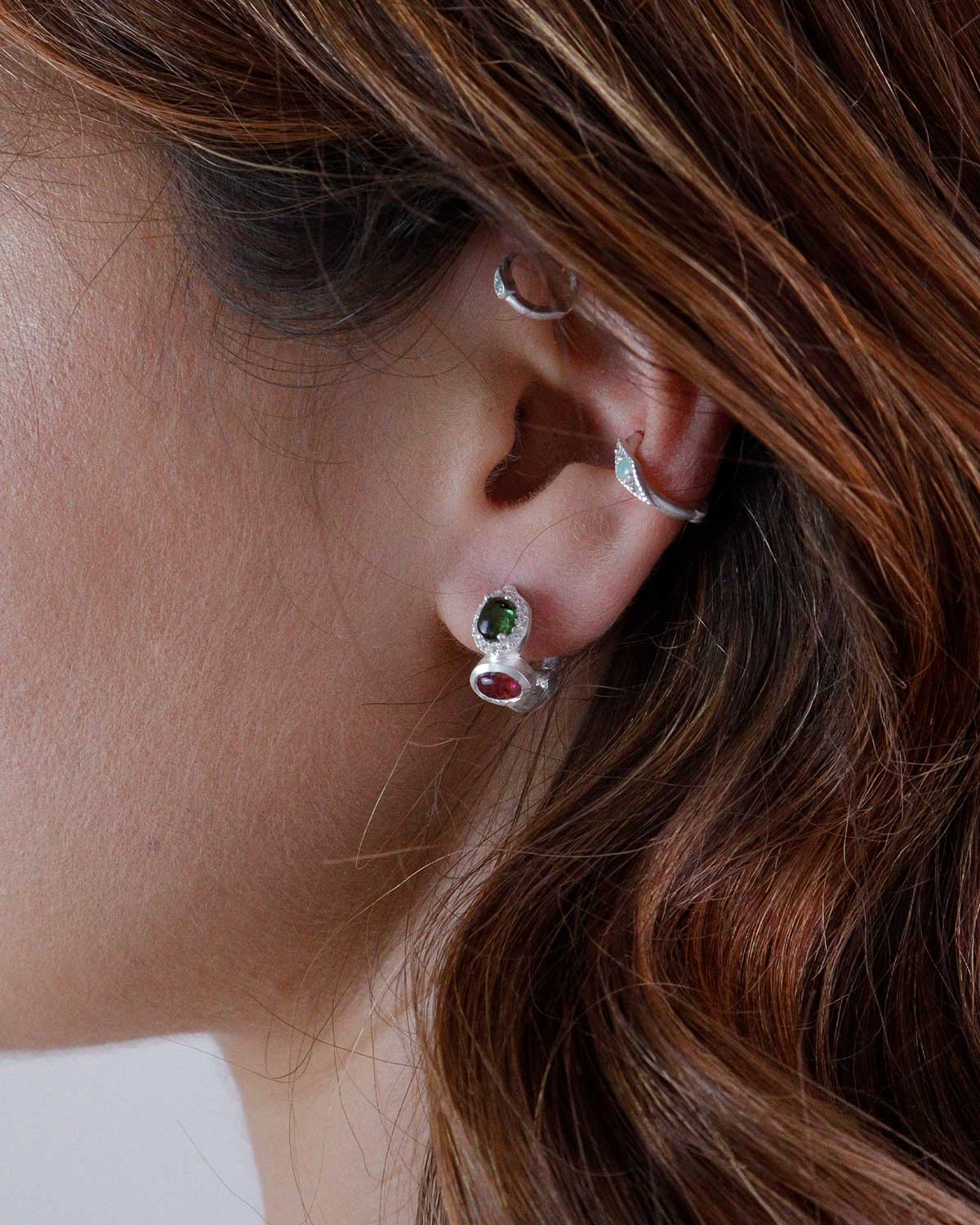 Close-up of silver mini hoops with mixed tourmaline gemstones and crystal detailing