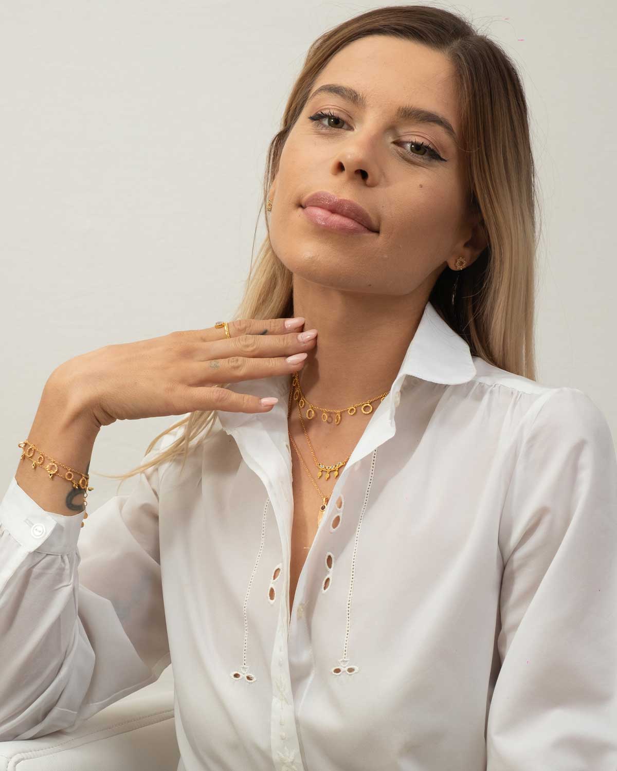 Model wearing gold adjustable necklace with hammered disc pendant