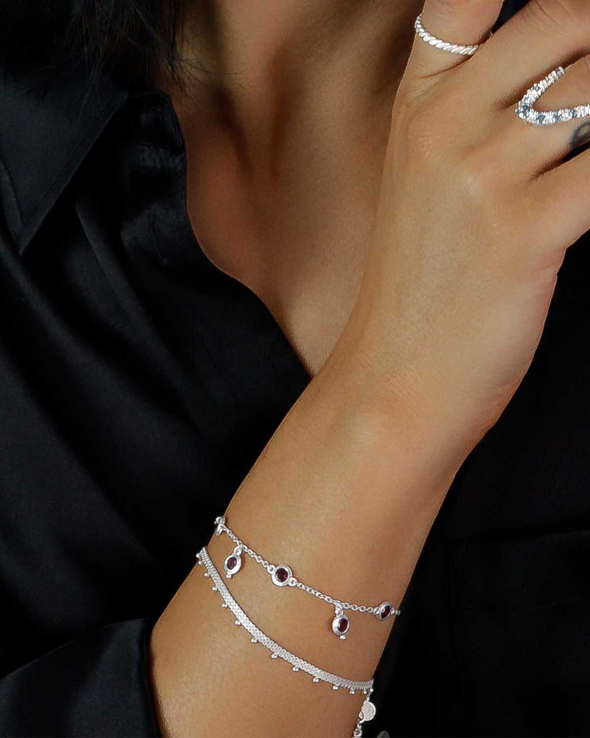 Adjustable sterling silver bracelet layered with other silver bracelets