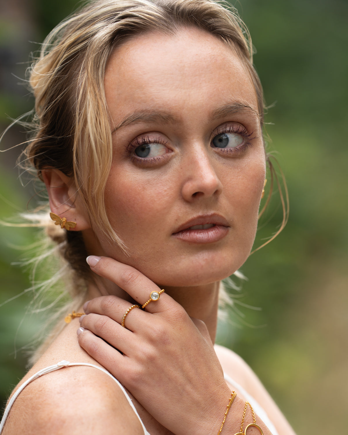 Model wearing gold ring with a natural clear crystal for mind, body, and soul balance