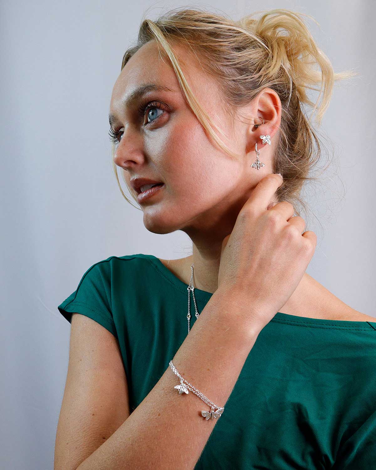 Close-up of silver bracelet showing intricate butterfly and bee charms