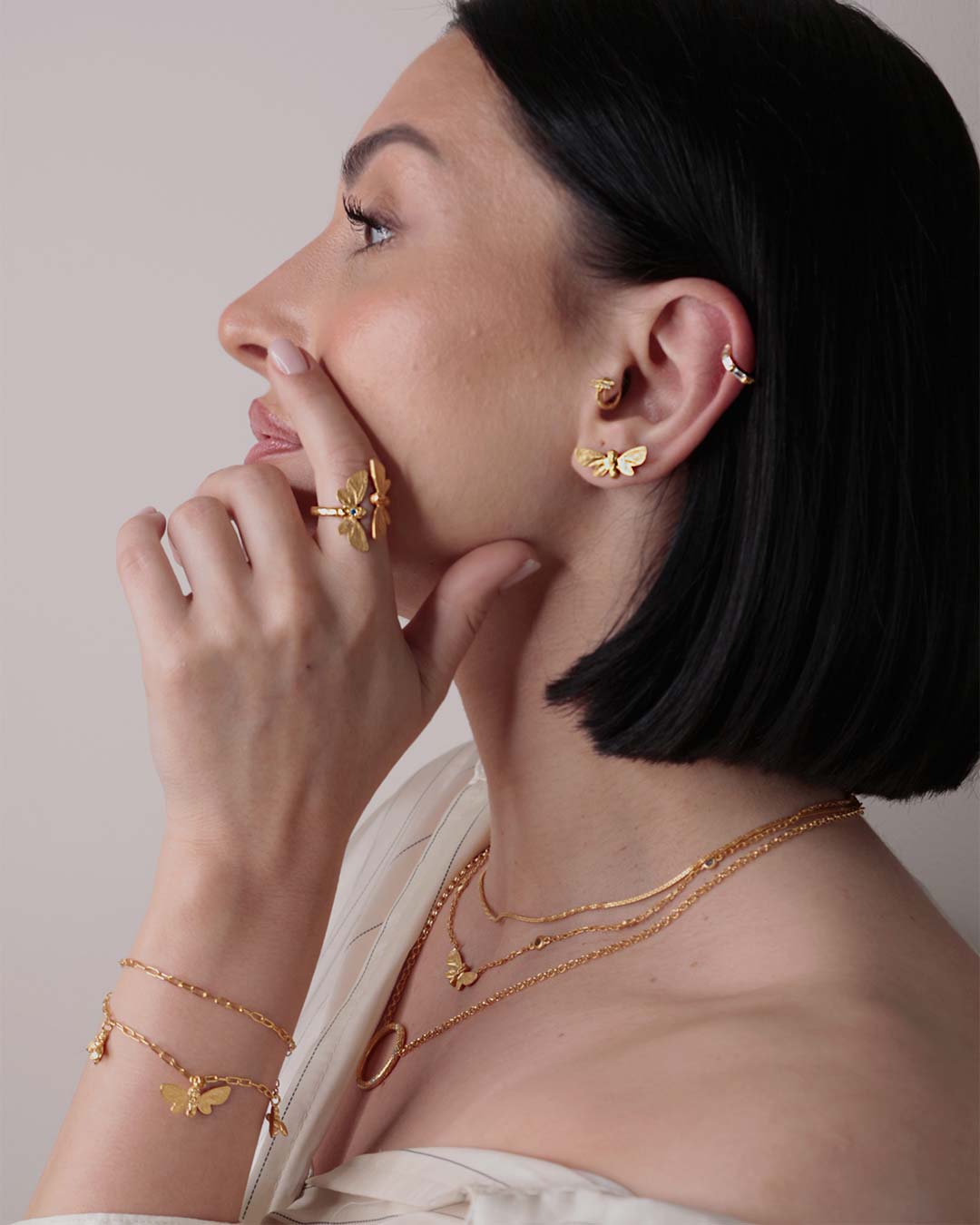 Model wearing gold butterfly stud earrings, showcasing their elegant fit