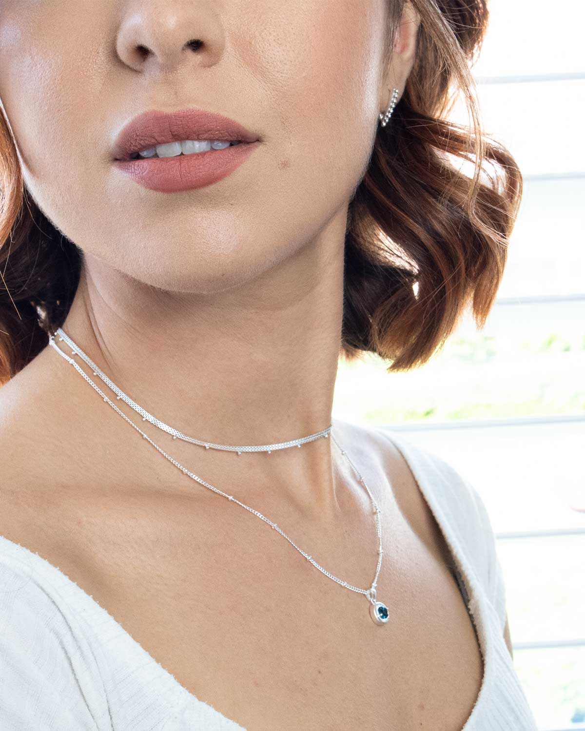 Model wearing sterling silver necklace with London blue topaz