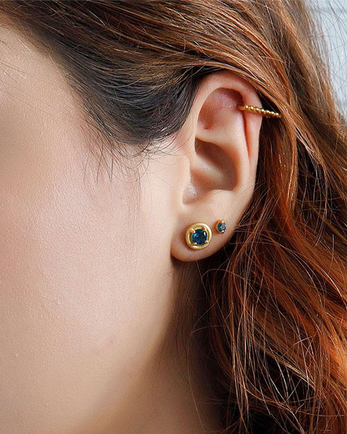 Close-up of London blue topaz stud earrings in gold vermeil