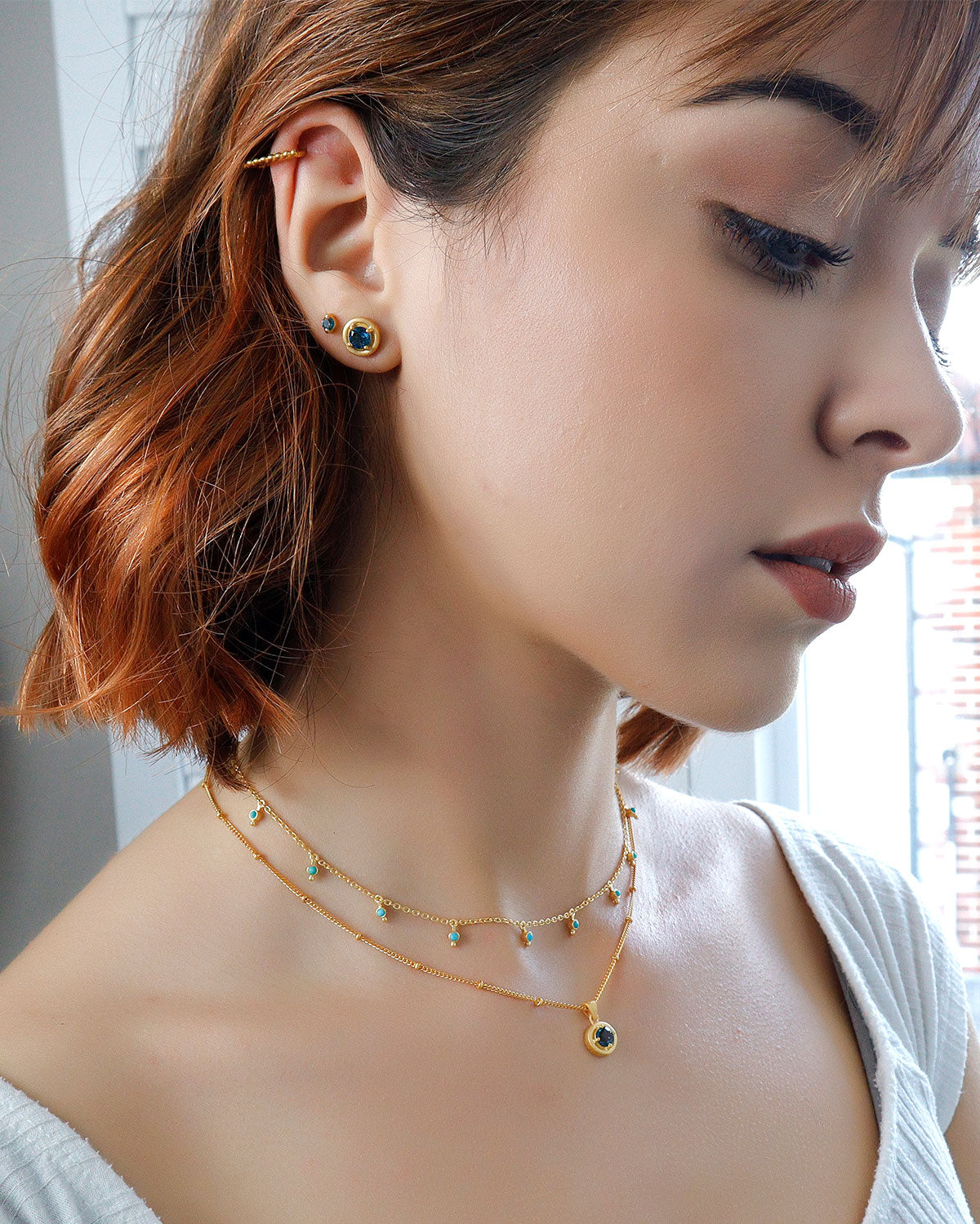 Model wearing gold vermeil London blue topaz stud earrings
