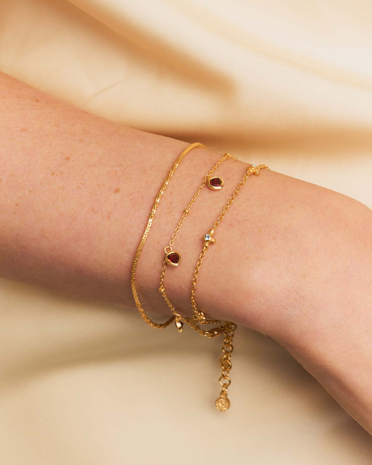 Close-up of gold bracelet showing dual chain patterns and adjustable clasp