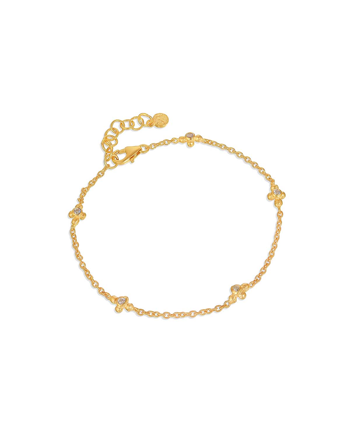 Gold bracelet with blue topaz gemstones and diamonds styled with other bracelets