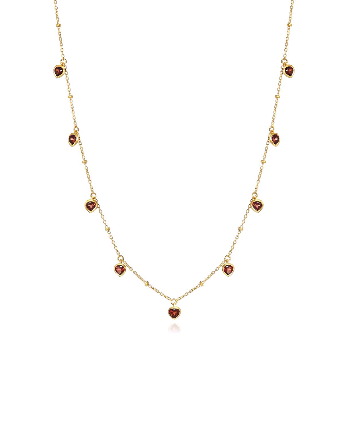 Gold necklace with a garnet heart charm and adjustable chain