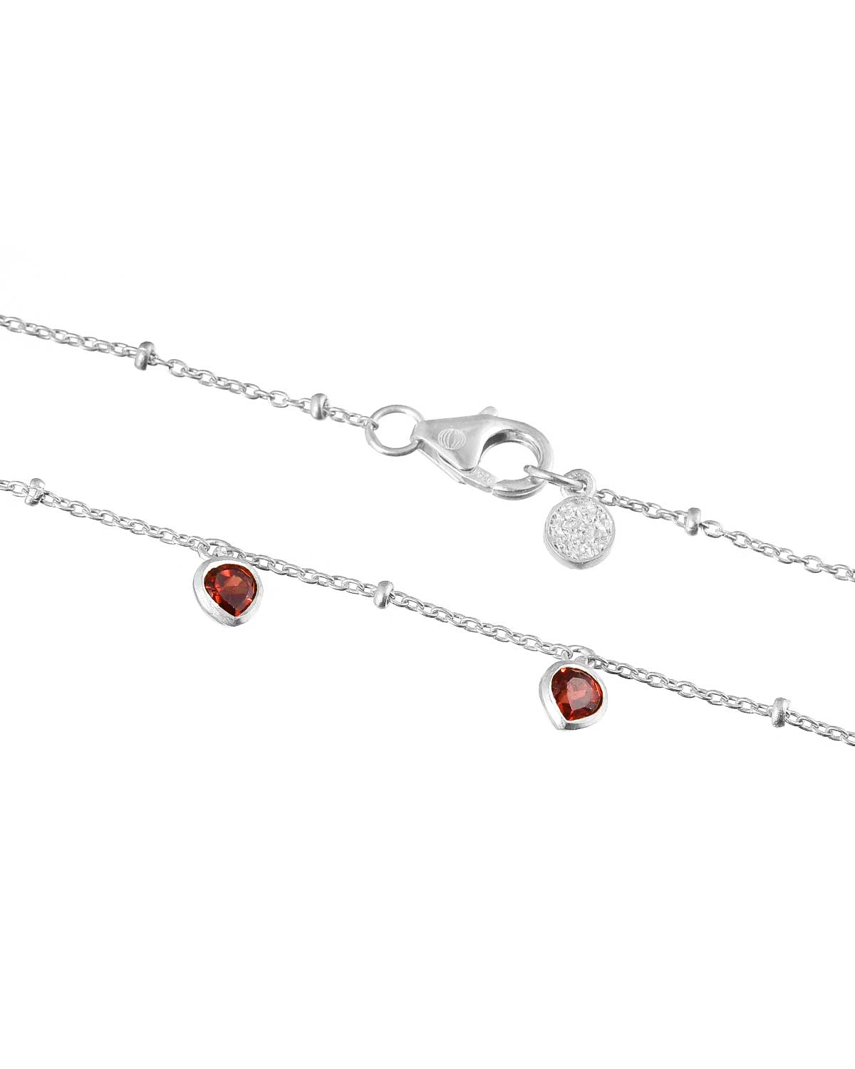 Close-up of sterling silver heart necklace with a garnet gemstone pendant
