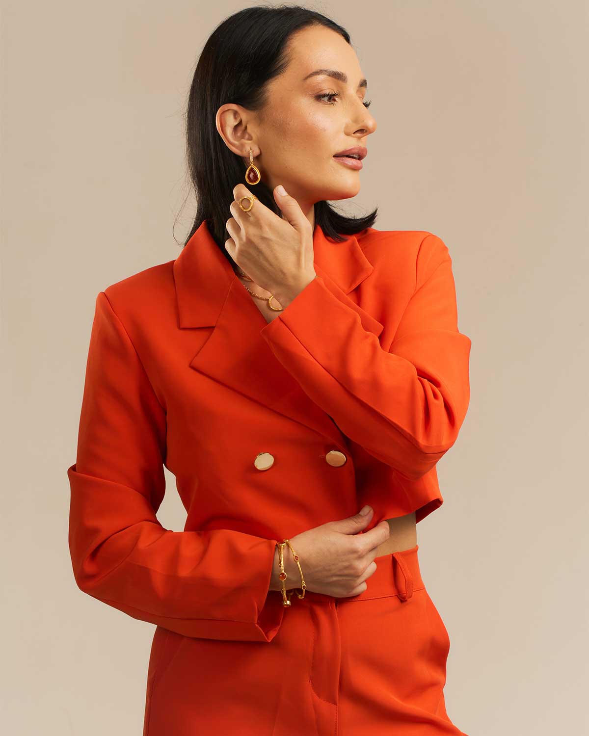 Model wearing a hammered gold bangle with a natural carnelian gemstone