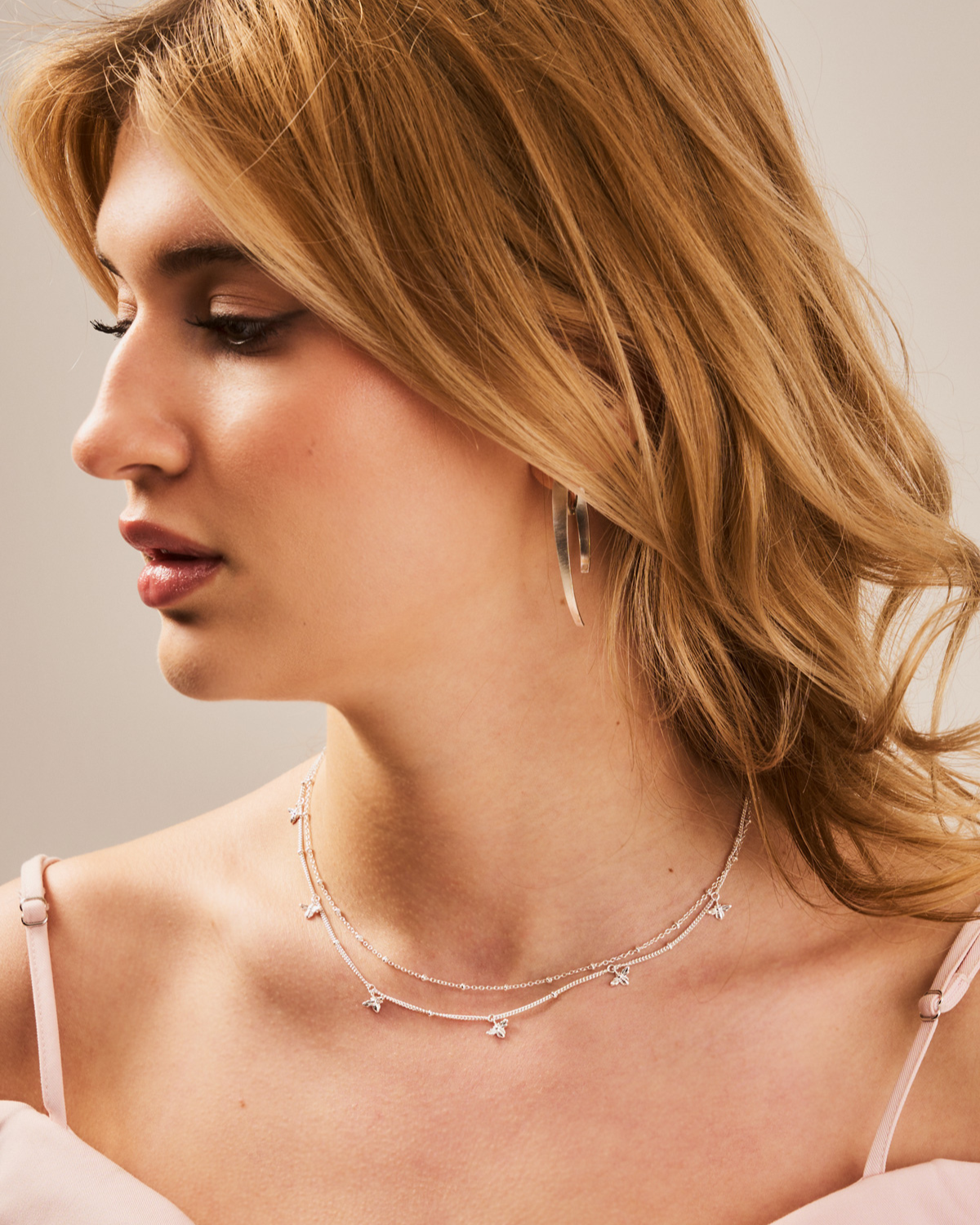 Side angle view of sterling silver necklace with handcrafted bee details