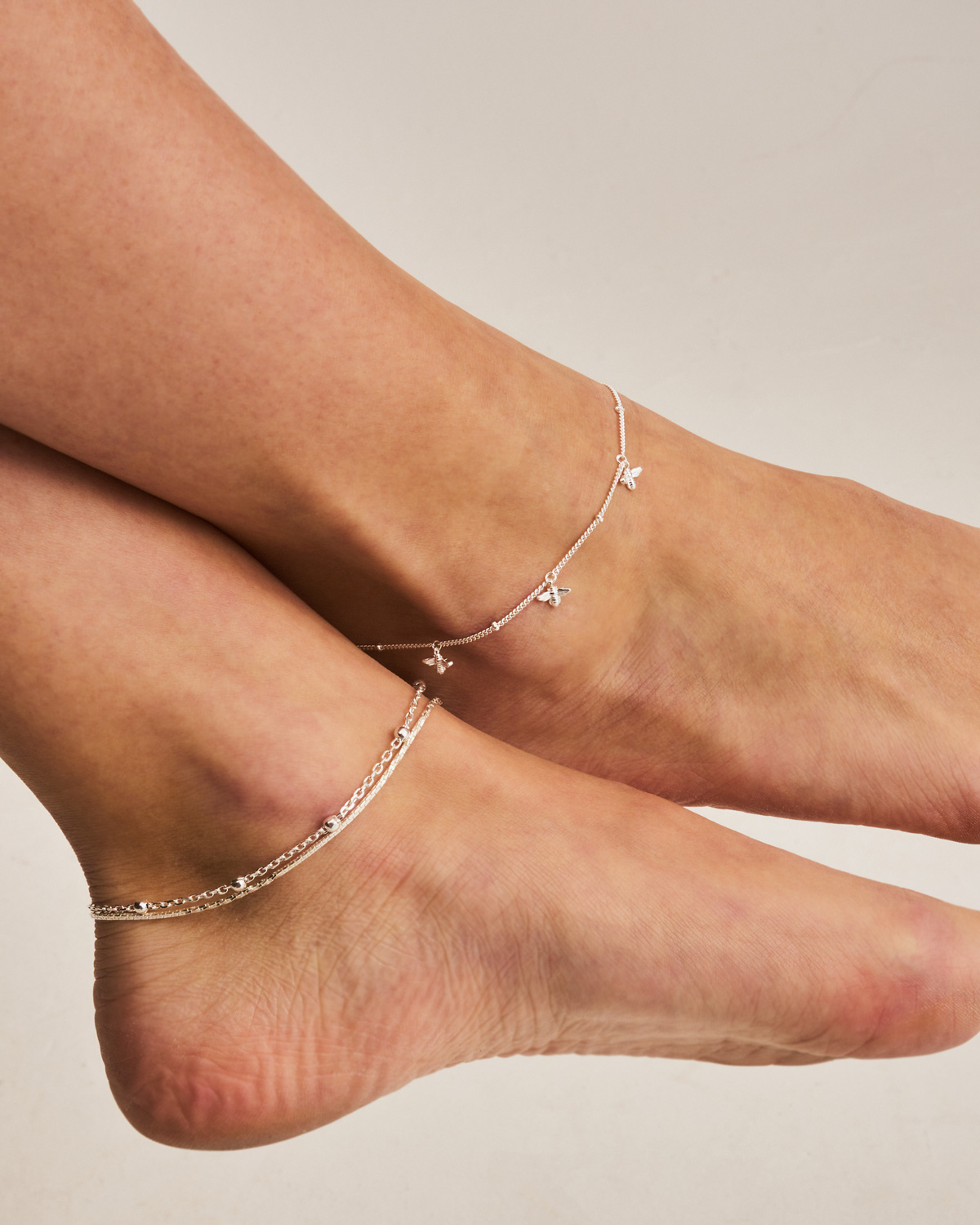 Detailed view of bee charms on a sterling silver anklet