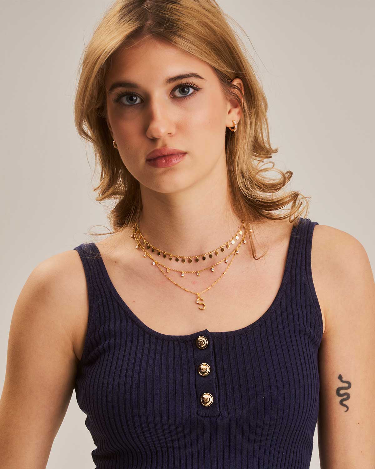 Model wearing gold choker necklace with small disk detailing