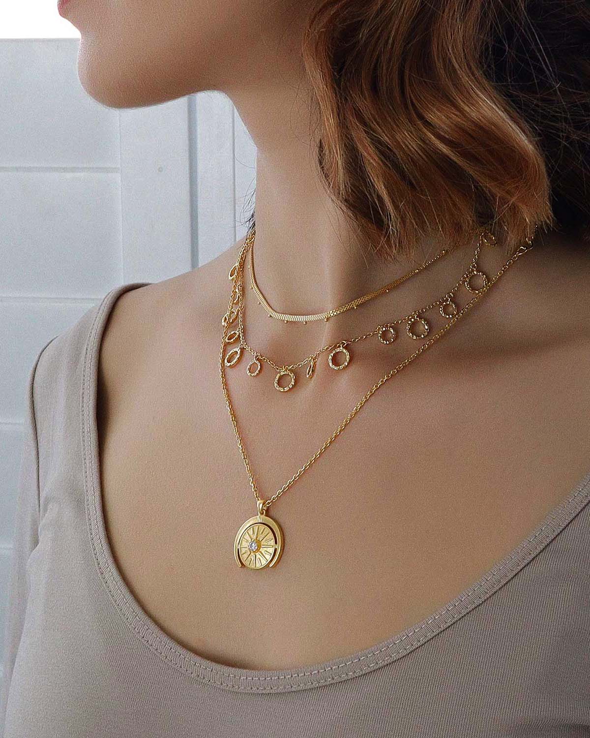 Model wearing gold vermeil necklace with a circular diamond pendant
