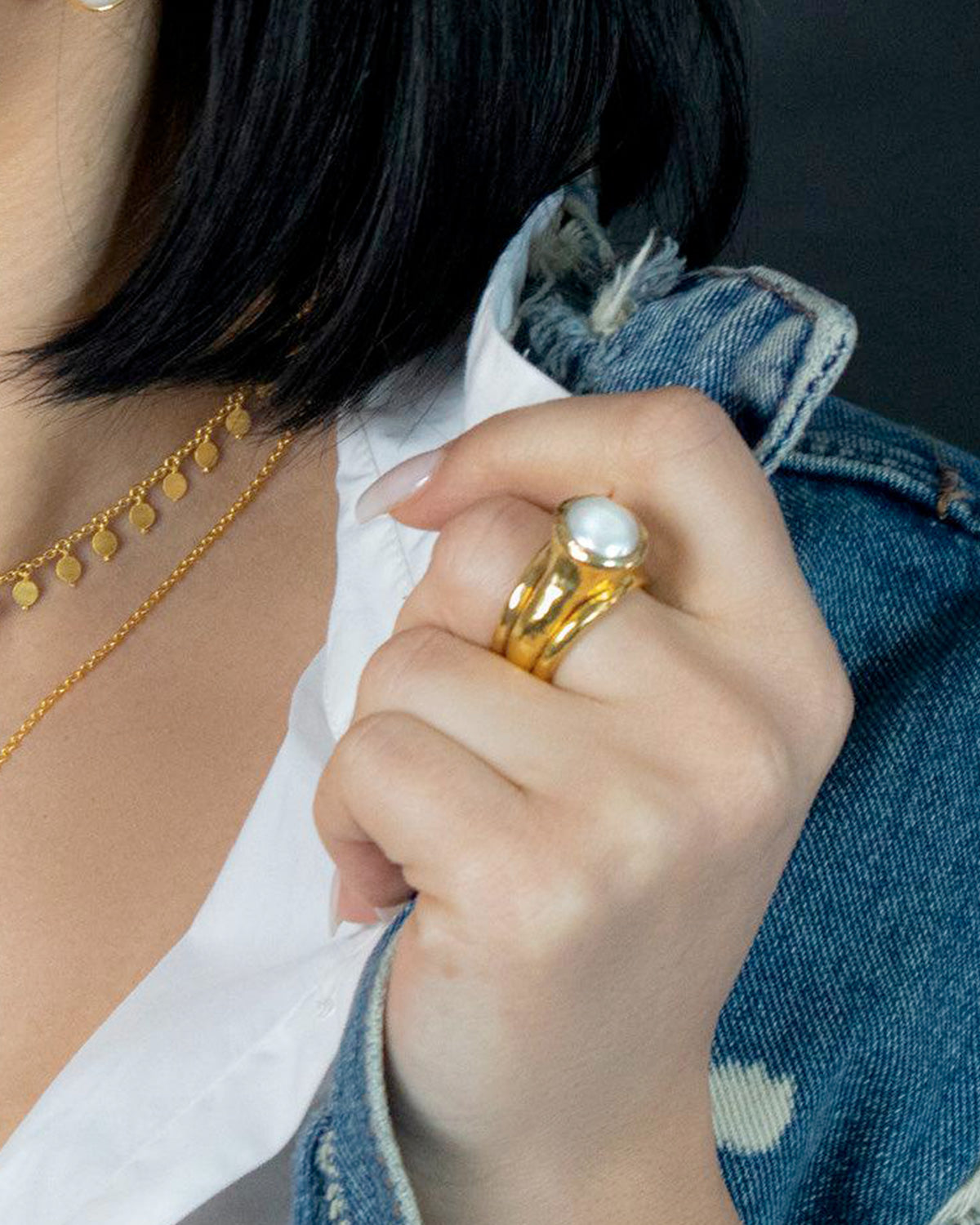 Model wearing silver ring with natural baroque pearl