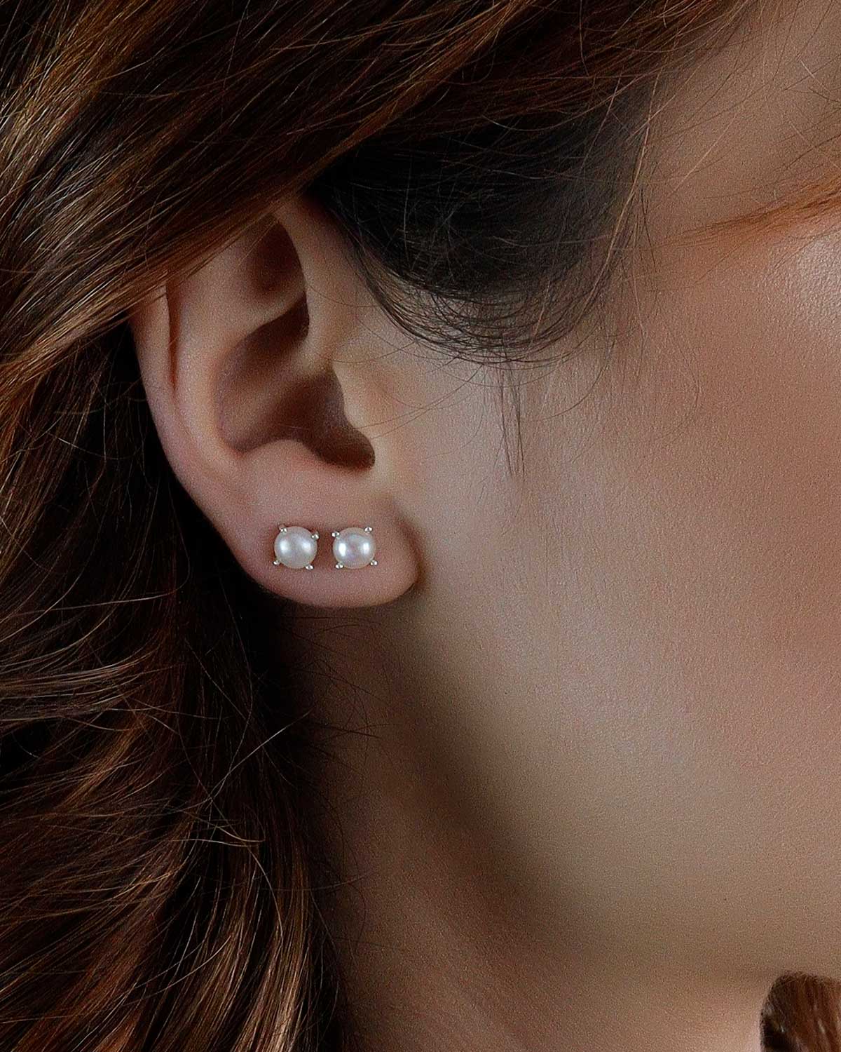 Close-up of sterling silver stud earrings with natural pearls