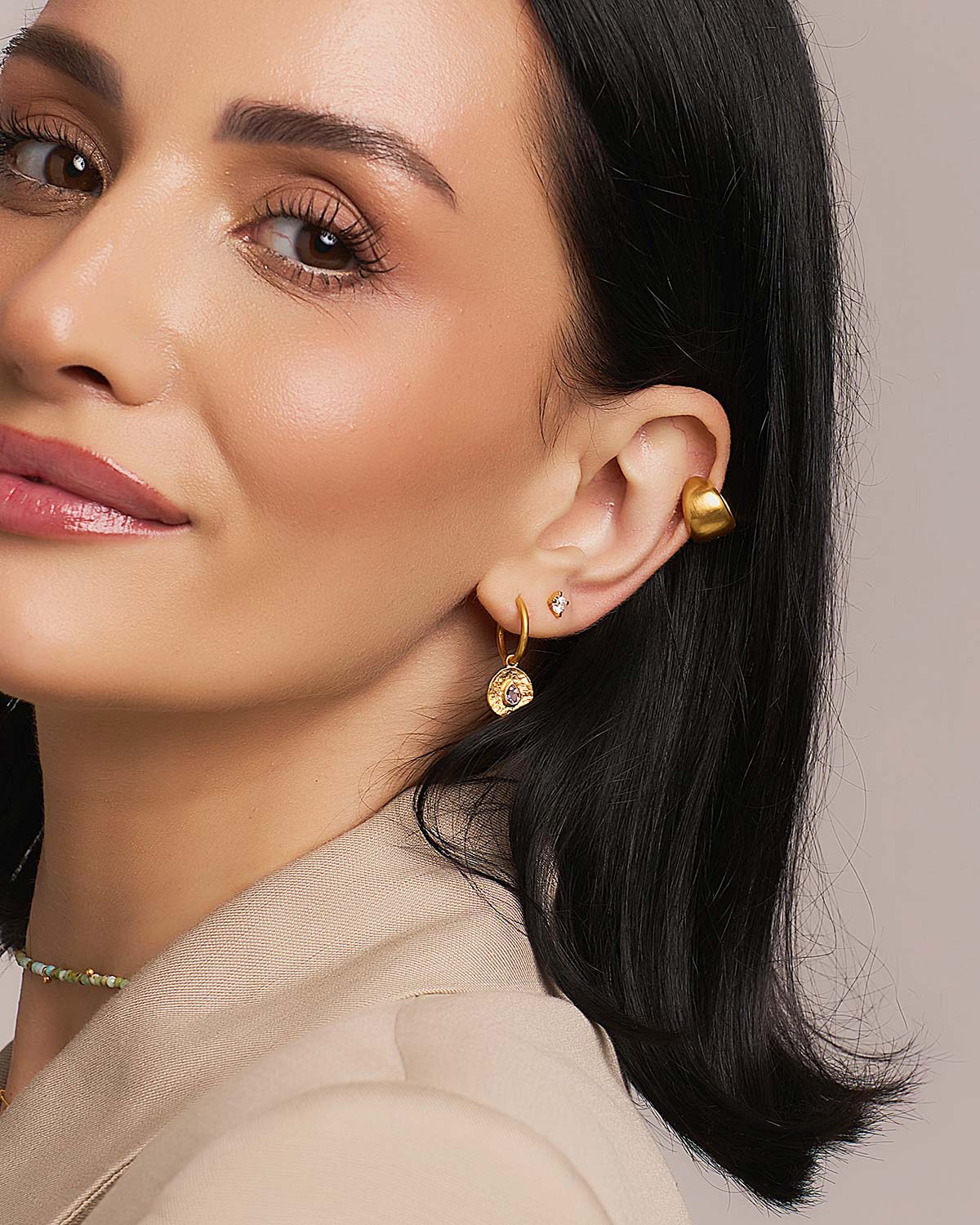 Model wearing chunky silver mini hoop earrings with a satin finish